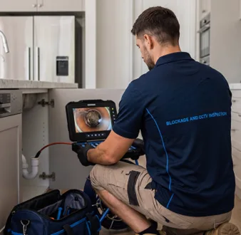 Plumber clearing a blocked toilet in a St Marys bathroom